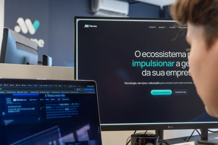 Monitor com o site da Marvee aberto numa mesa do escritório