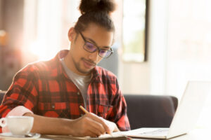 Homem pesquisando em notebook sobre BPO Financeiro