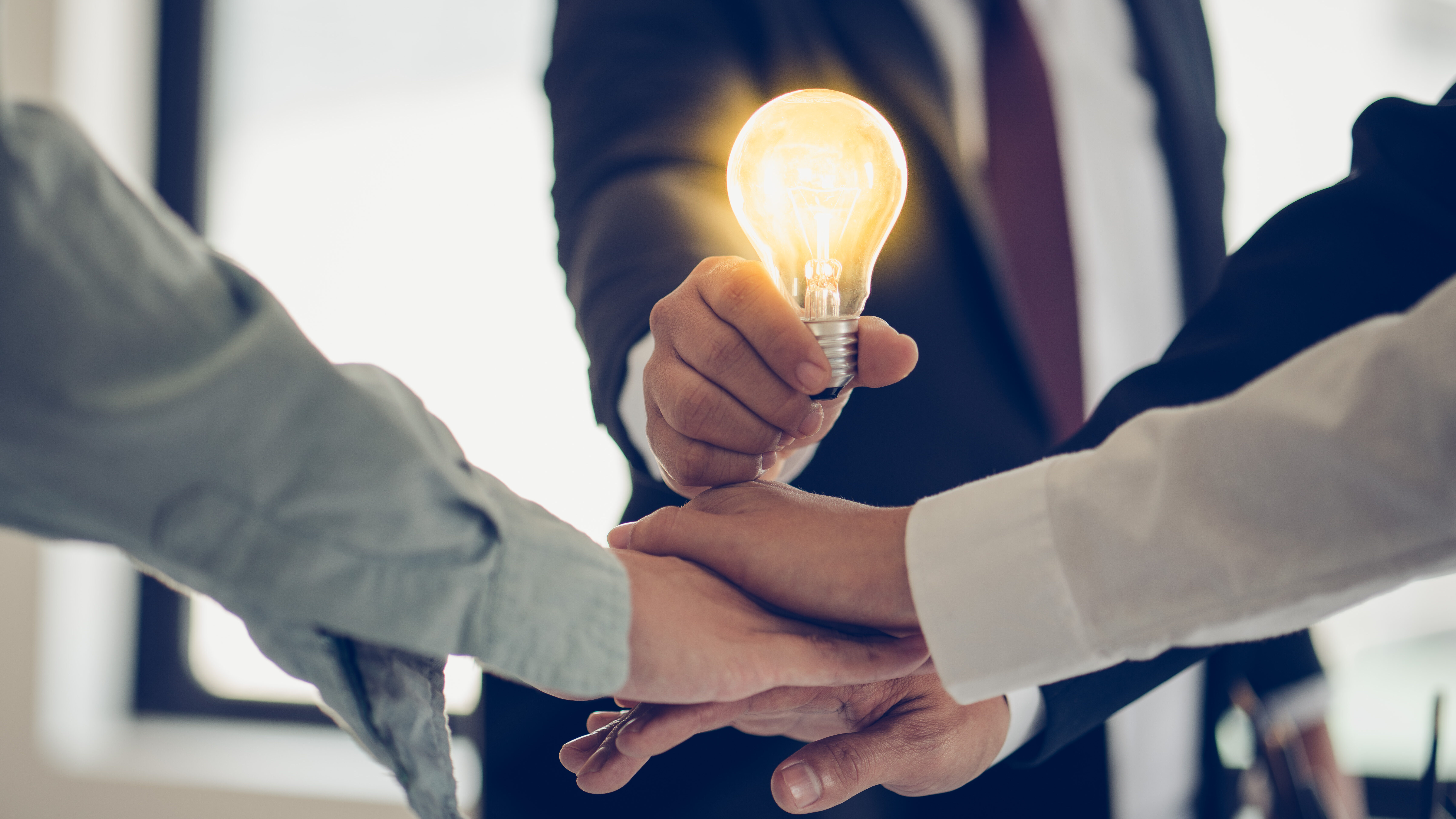 como abrir um cnpj e dar o primeiro passo rumo ao sucesso 1 empresário segurando uma lâmpada acesa, simbolizando ideias e inovação no momento de descobrir como abrir um cnpj para seu negócio.