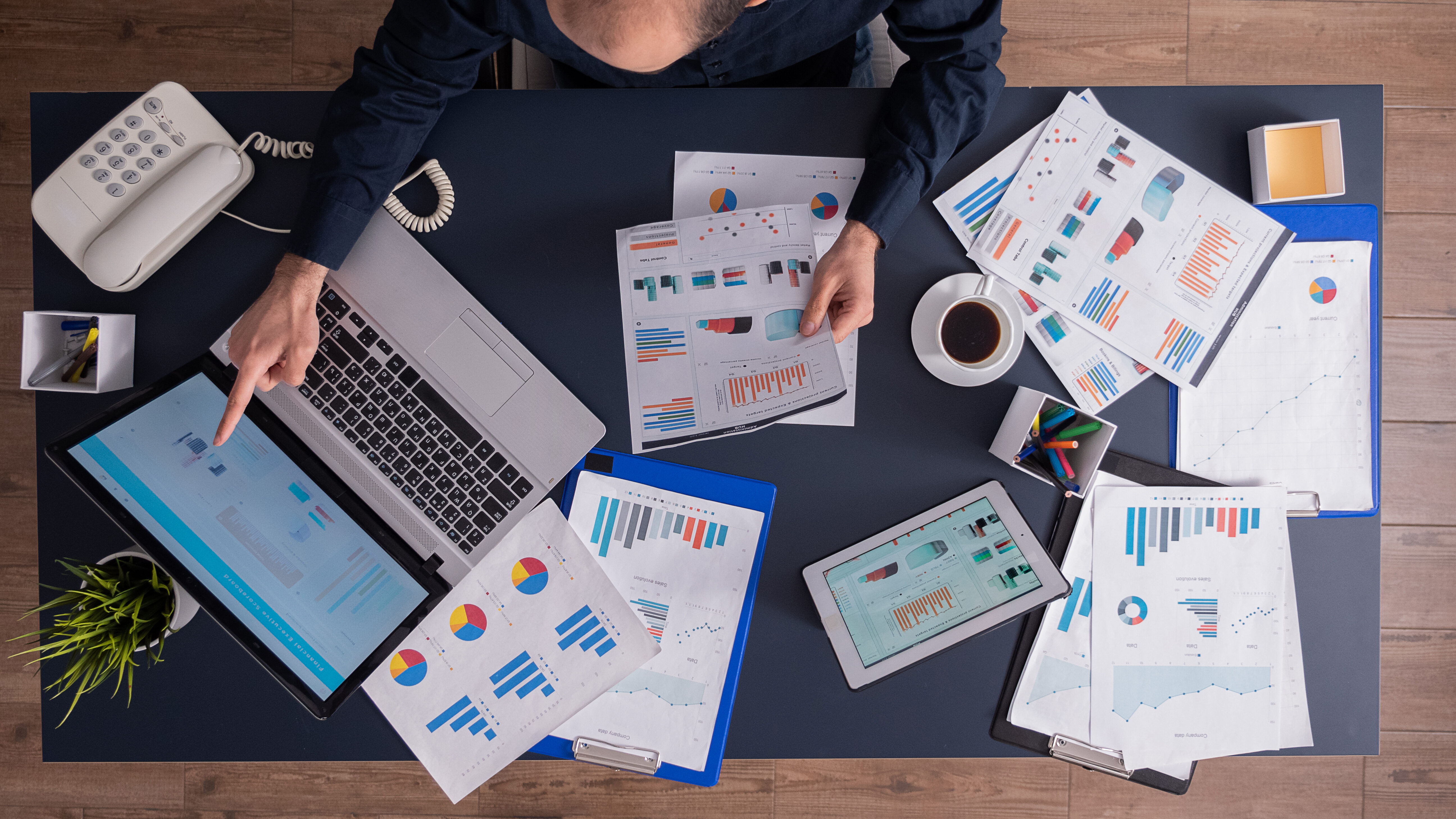 planejamento financeiro empresarial para agências de marketing 1 homem analisando relatórios financeiros ao computador, representando a importância do planejamento financeiro empresarial para organização e controle das finanças corporativas.